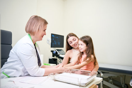 Doctor reassures a girl before a medical procedureの写真素材