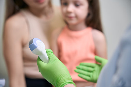 Gloved hand prepares ultrasound scan for mother and daughter