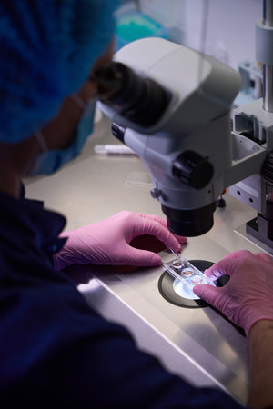 Doctor positioning a sample under a microscope for analysis