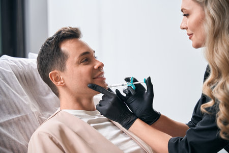 Woman beautician making botulinum toxin injections into clients chinの写真素材