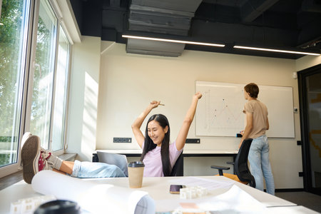 Creative guy works in team with Asian woman in democratic environment