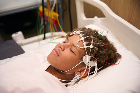 Close-up of young patient lying still with EEG electrodes on scalpの写真素材