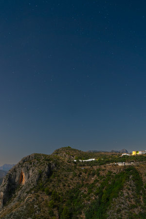 Serene night sky over mountains and buildingsの写真素材