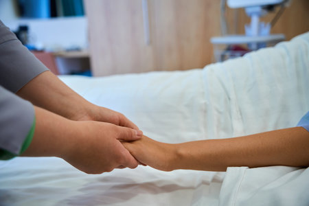 Hospital nurse comforting female patient during intravenous therapyの写真素材