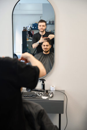 Hairdresser talking with client in barber shopの写真素材