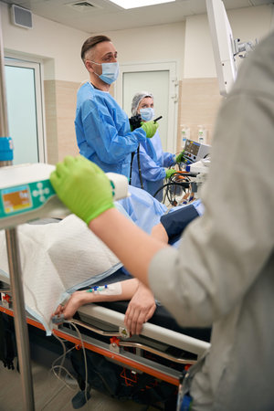 Three medical professionals in operating room with patient