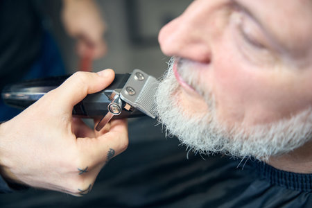 Adult man during haircut beard with hair-clipper
