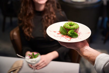 Happy woman serving elegant chocolate dessert in restaurant