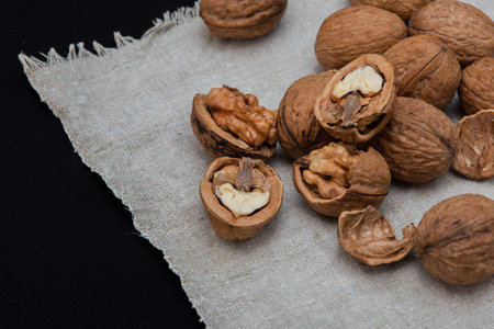 Walnuts on a linen napkin on a black background. Close-up.
