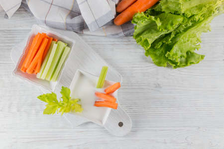 Healthy breakfast with yogurt, celery and carrot sticks. Diet and Healthy snack food. top viewの写真素材