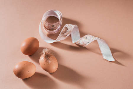 Happy Easter card with natural color eggs and feathers on beige backgroundの写真素材