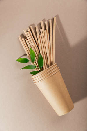 Disposable paper tableware. Cups and straws on beige background. Plastic free and zero waste concept.の写真素材