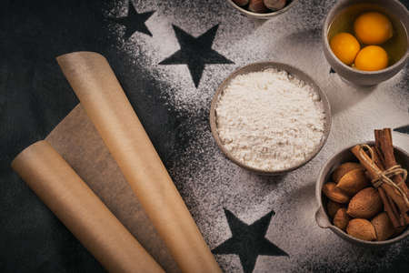 Bakery background for cooking Christmas baking with rolling pin, whisk, scattered flour, eggs, nuts. Homemade festive Christmas baking concept - delicious homemade biscuits or cookiesの写真素材