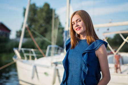 Attractive woman posing on the marina at a sunny summer day at the river and enjoying at happy holidaysの写真素材