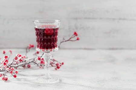 Glass of cherry liqueur oe wine on white background. Christmas or new year party celebration concept. Winter holidays concept.の写真素材