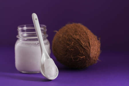 Coconut, flakes and coconut oil in jar on purple backgroundの写真素材