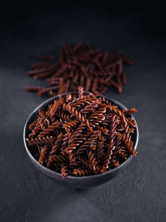 Organic uncooked Buckwheat Fusilli pasta on dark background. Wholegrain gluten free noodles. Healthy food concept.の写真素材