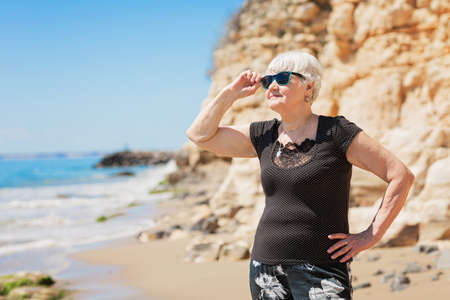 Senior woman of retirement age standing on the shoreの写真素材