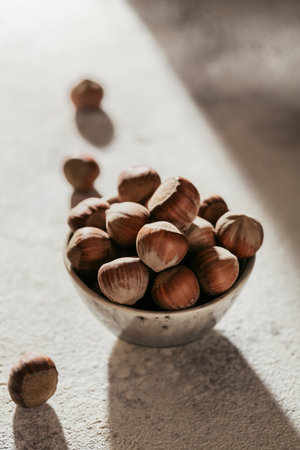 Pile of hazelnuts filbert in a bowl on a white backgroundの写真素材