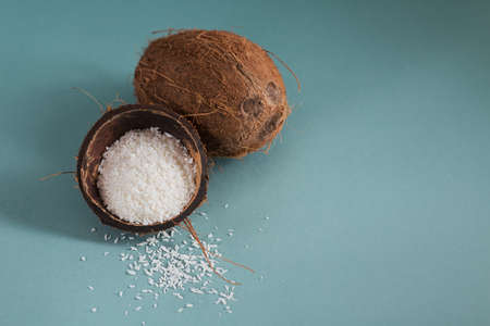 Whole coconut with coconuts flakes on a blue backgroundの写真素材