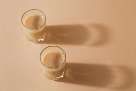 Short glasses of Irish cream Liquor or Coffee Liqueur on light beige backgroundの写真素材