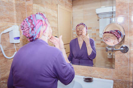 Elderly woman taking care of her faceの写真素材