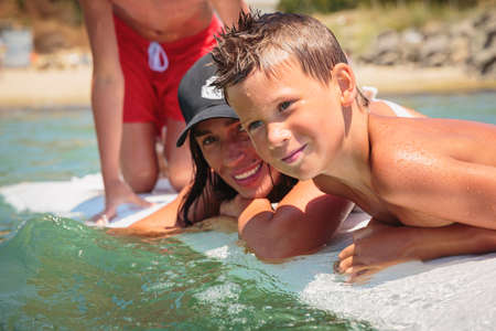 Mom with her two sons having fun at the sea