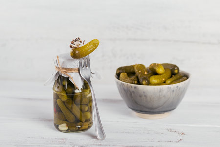 Preserving pickled cucumbers, seasonings and garlic on white wooden tableの写真素材