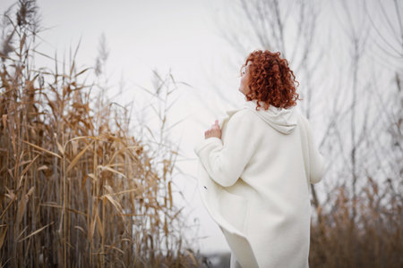 Pretty young woman in trendy white clothes poses in motionの写真素材