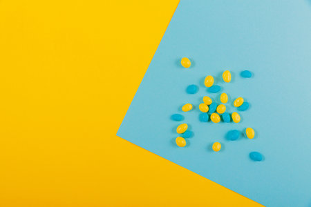 Delicious Easter holiday chocolate colorful candies on yellow blue backgroundの写真素材