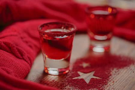 Two glasses of red liqueur on wooden background. Winter holidays or new year party celebration conceptの写真素材