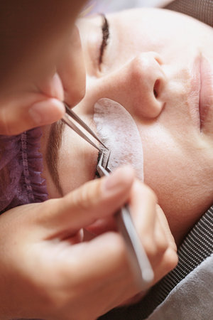 Eyelash extension procedure. Female eye with long eyelashesの写真素材