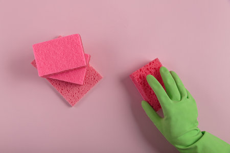 Hand in rubber glove holding washing spongeの写真素材