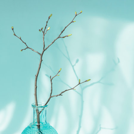 Tree branch with buds in vase on light blue backgroundの写真素材