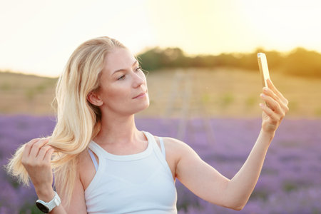 Woman taking selfie in lavender fieldの写真素材