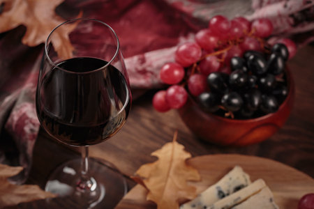 Autumn picnic with wine and cheese platter, fruits and dry leavesの写真素材