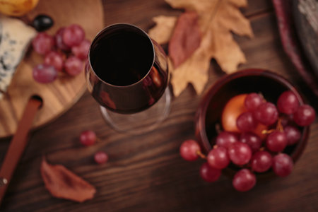 Autumn picnic with wine and cheese platter, fruits and dry leavesの写真素材