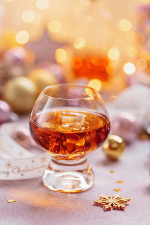 Glass of whiskey or bourbon with festive Christmas decorationの写真素材
