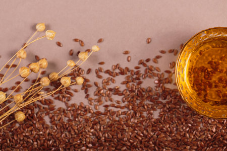 Brown linen seeds, flaxseed vegetable oil on beige background. Flaxseed background. Healthy super foodの写真素材