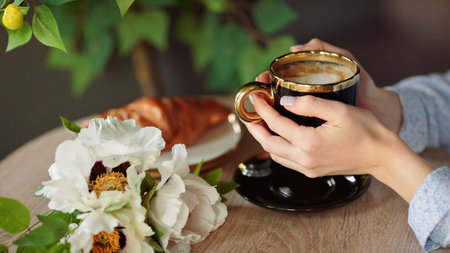 Closeup of womans hands holding black cup of coffeeの写真素材