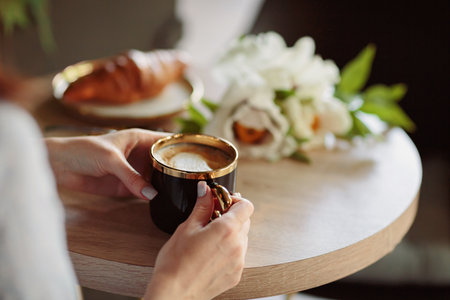 Unrecognizable woman drinking coffee in cafeの写真素材