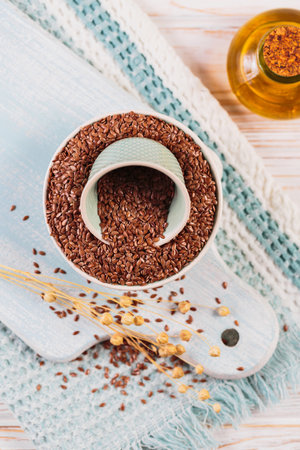 Brown linen seeds, flaxseed vegetable oil on white wooden background.の写真素材