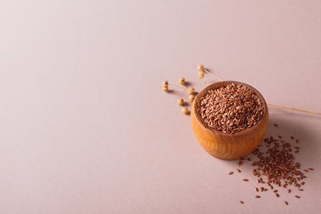 Brown linen seeds or flaxseed on beige backgroundの写真素材