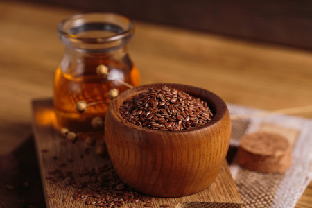 Brown linen seeds, flaxseed vegetable oil on wooden backgroundの写真素材