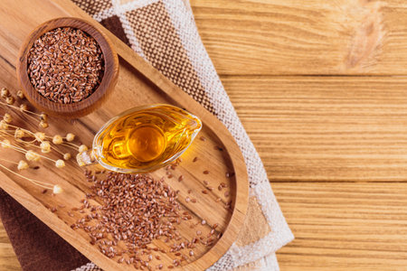 Brown linen seeds, flaxseed vegetable oil on wooden backgroundの写真素材