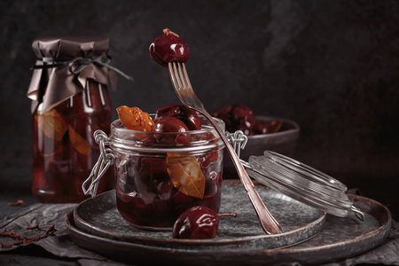 Marinated plums with spices in glass jar on the kitchen tableの写真素材