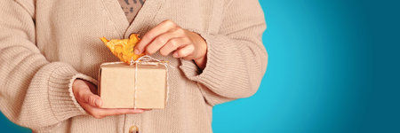 Woman holding handcrafted gift box with autumn leaves