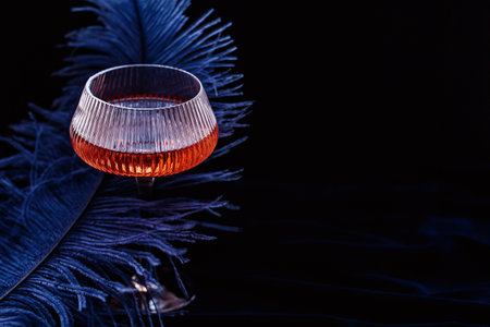 Beautiful glamorous romantic greeting card, wine glass and featherの写真素材