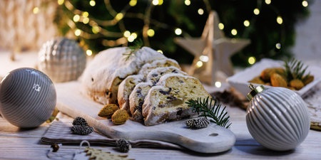 Traditional Christmas stollen decorated with pinecones and lightsの写真素材