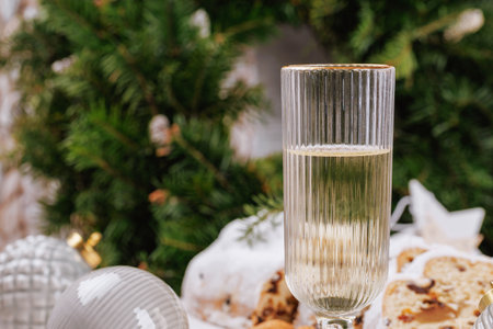 Holiday champagne glass with stollen and festive ornamentsの写真素材